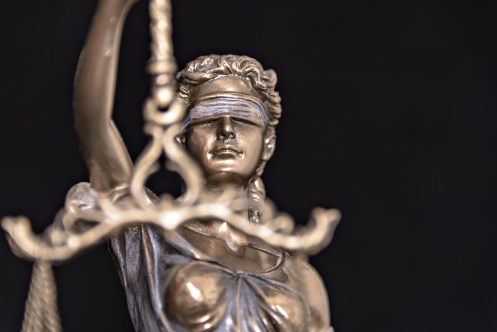 A close-up of the blindfolded statue of Lady Justice holding the scales, representing civil plaintiff litigation and personal injury trial law.