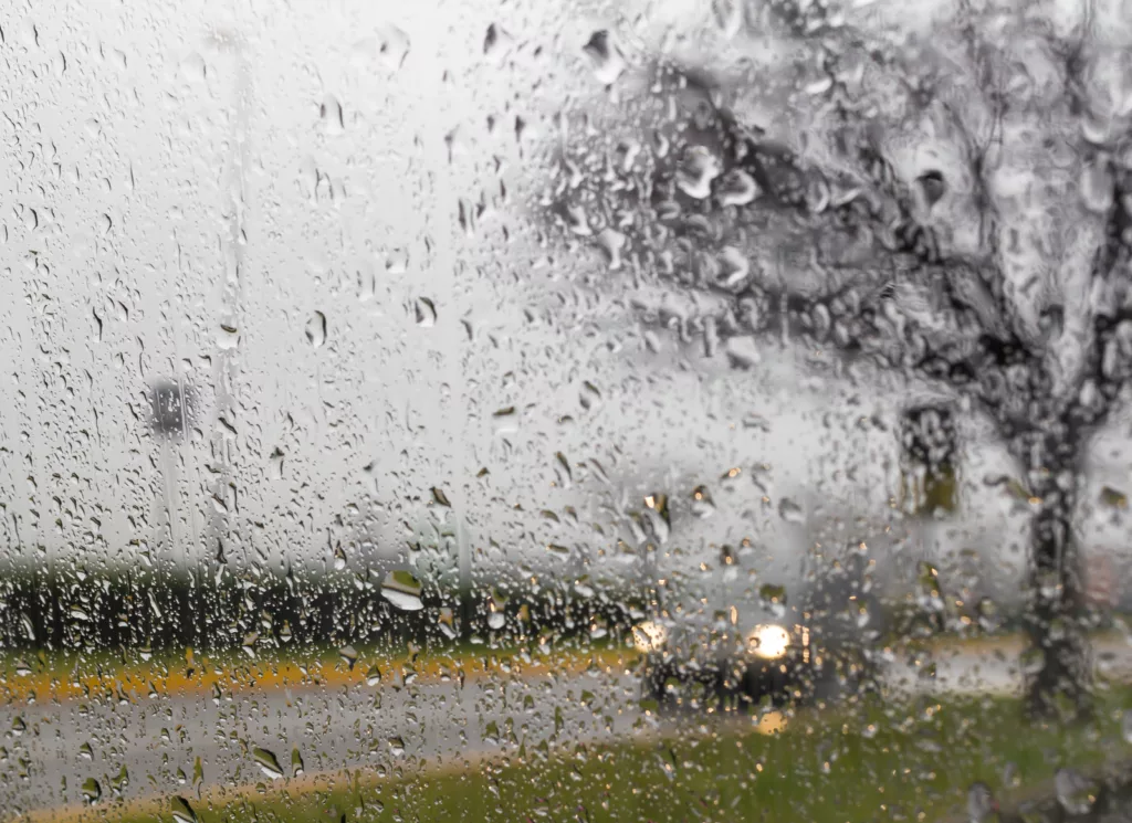 rainy road through wet windshield — T-bone collision risk