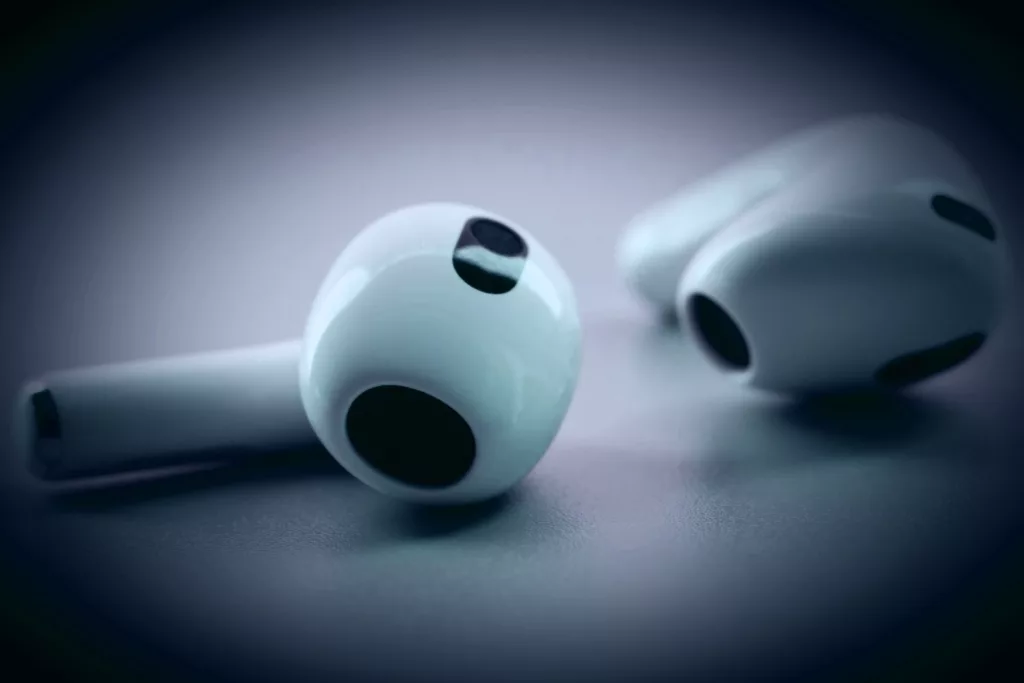 Bluetooth wireless earbuds on gray background — illegal to wear while driving in Florida
