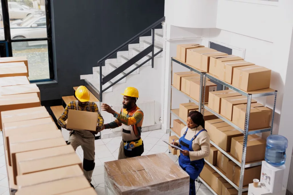Warehouse workers lifting heavy boxes risking a workplace lifting injury