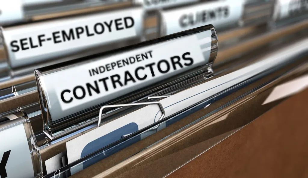 A close-up of office Rolodex dividers labeled Self-Employed and Independent Contractors, illustrating workers' compensation eligibility options for non-traditional employees.